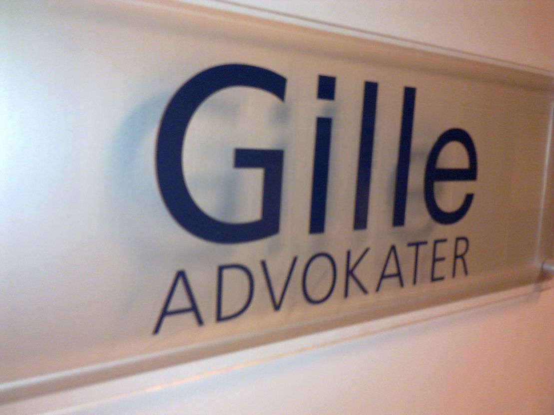 Glasskilt med logoen til Gille advokater DA